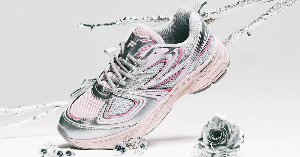 Step Up Your Style: Fila Shoes Where Comfort Meets Cool! Sleek pink and gray Fila sneaker on white background with silver accents.