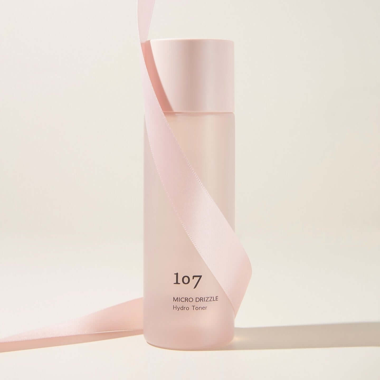 107 Micro Drizzle Hydro Toner 155ml bottle with pink ribbon, elegant skincare packaging