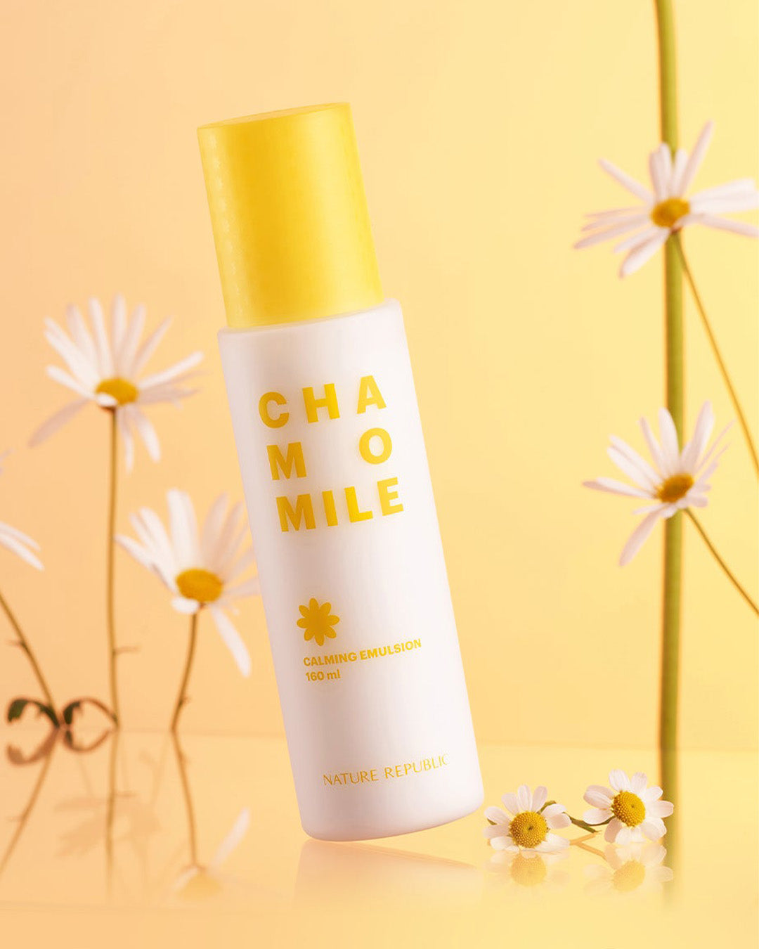 Chamomile calming emulsion bottle with daisy flowers on a soft yellow background.