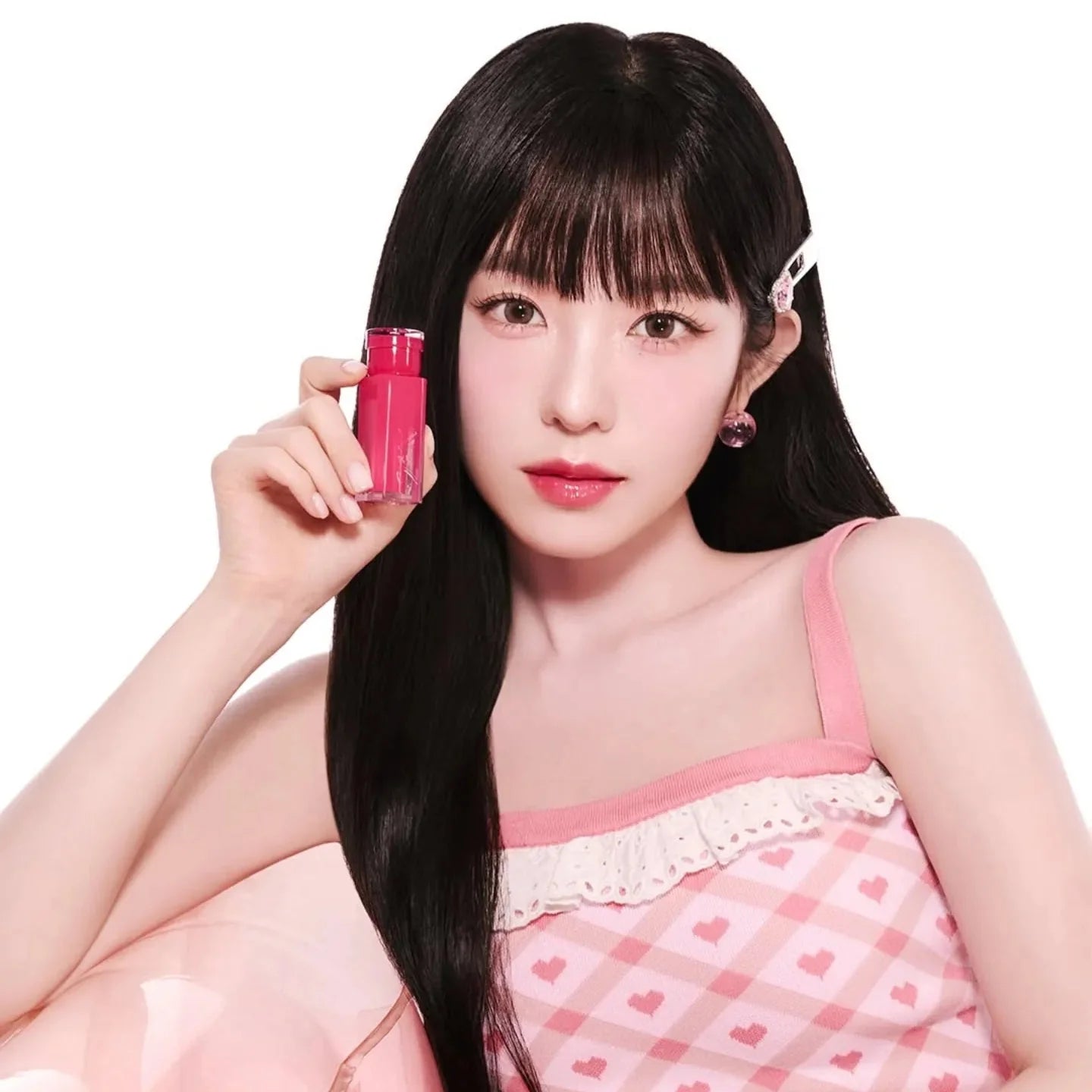 Woman holding 2an Glaze Bouncing Tint in a pink outfit