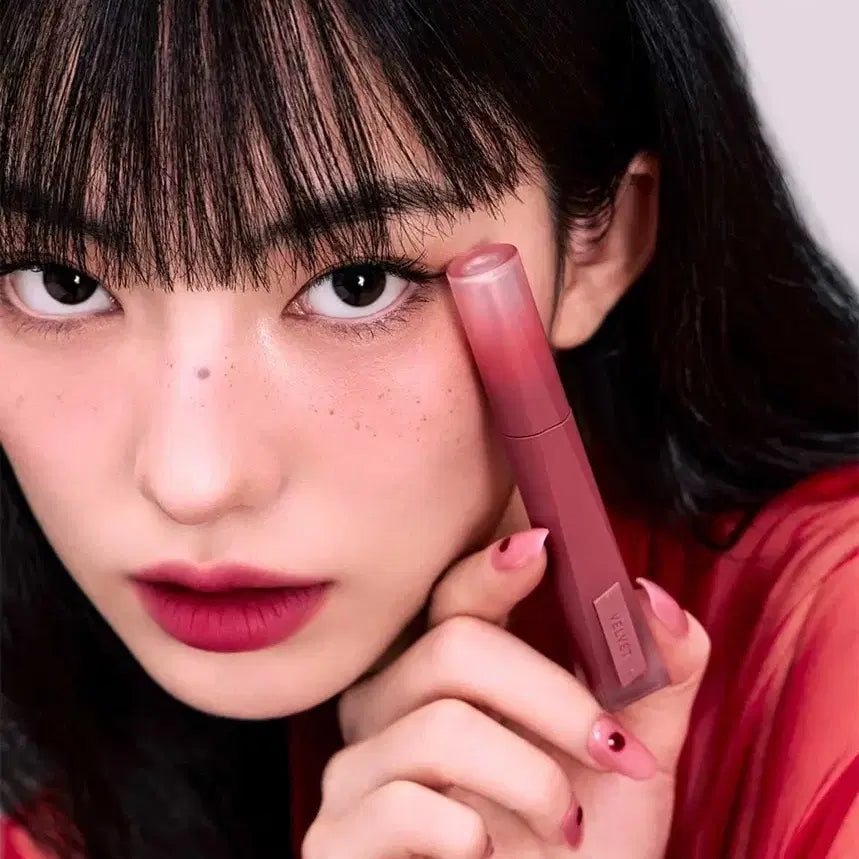 Person holding 3CE Velvet Lip Tint Plush in close-up view
