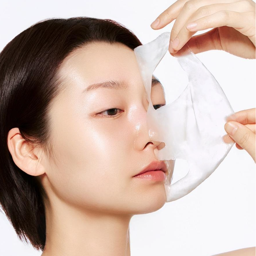 Model applying ABIB Blemish Collagen Wrapping Mask Glutathione Film 100ml for skincare routine.