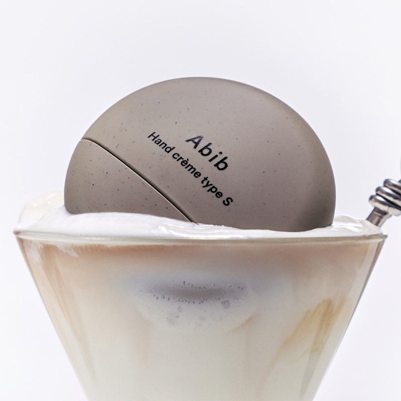 ABIB Hand Cream 3 Types displayed on a creamy dessert in a glass.
