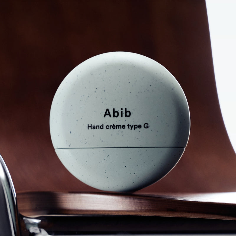 ABIB Hand Cream 3 Types - sleek container design on wooden background.