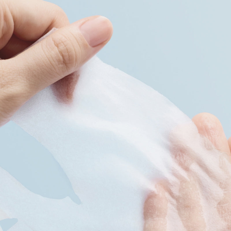 Close-up of hand holding ABIB Hyaluronic Acid Moisture Sheet Mask Essential Fit, showcasing its texture and quality.