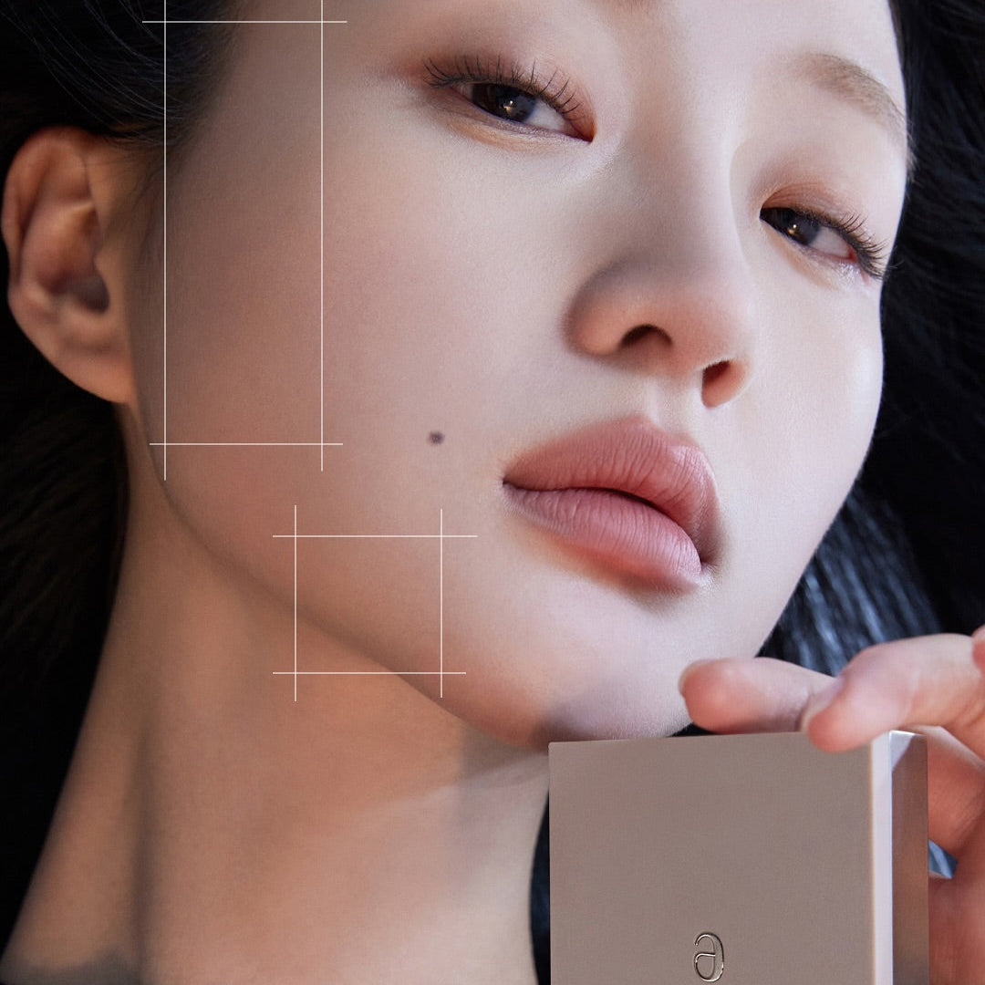 Close-up of a person holding a makeup product, showcasing AMELI Maroon Shading, emphasizing smooth skin and elegant packaging.