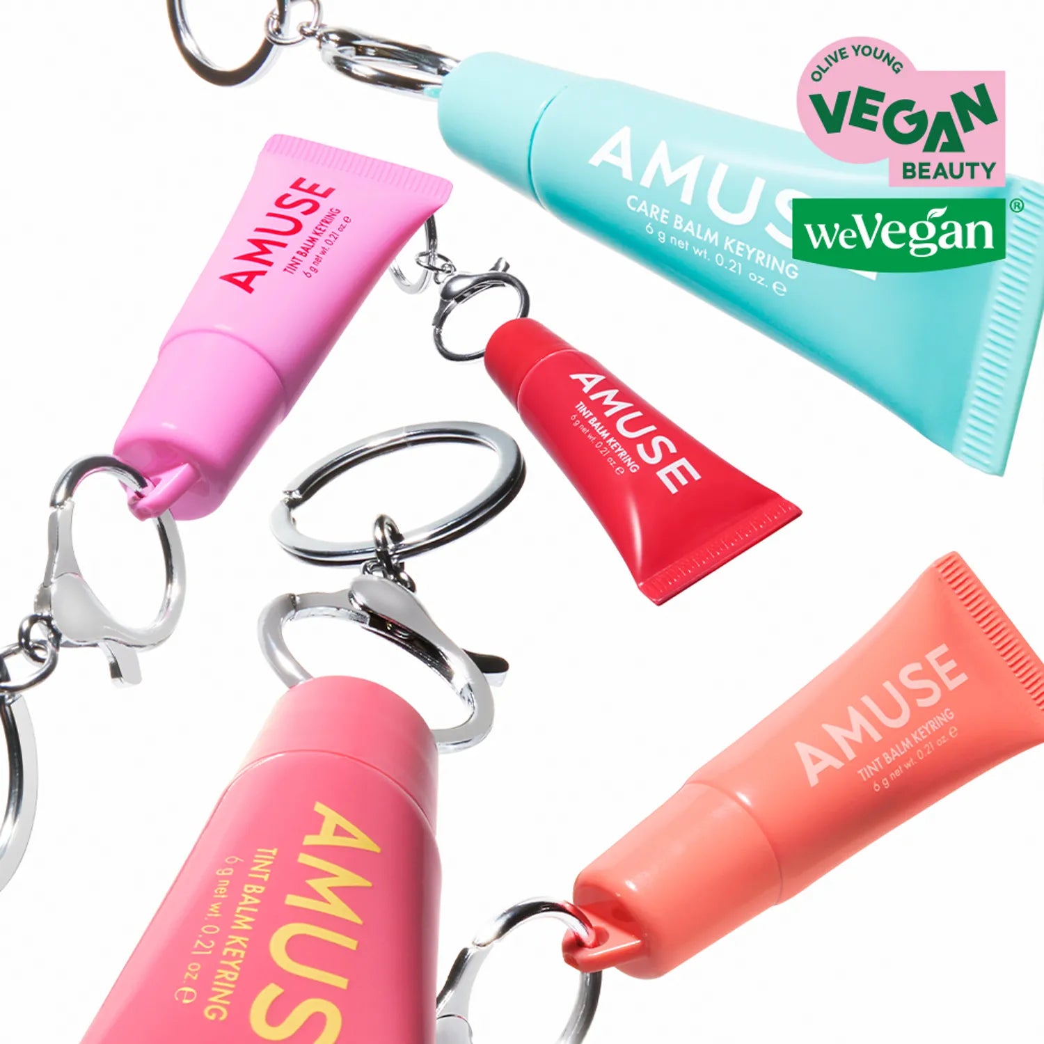 Colorful vegan AMUSE TINT BALM KEYRING collection displayed with keyring attachments, highlighting unique colors and eco-friendly design.