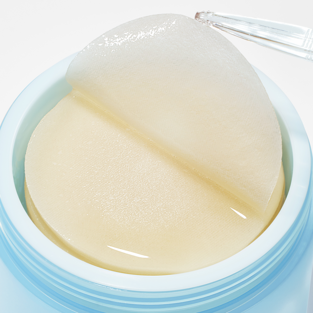 Image of ANUA 8 Hyaluronic Acid Catechin Calming Pads 110 Pads in a jar with a pair of tweezers lifting a pad.