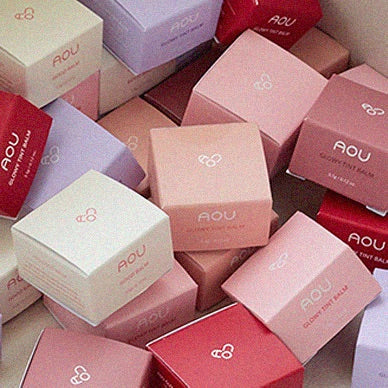 AOU Floofy Matte Balm packaging in various pastel colors, showcasing the brand's elegant and vibrant design.