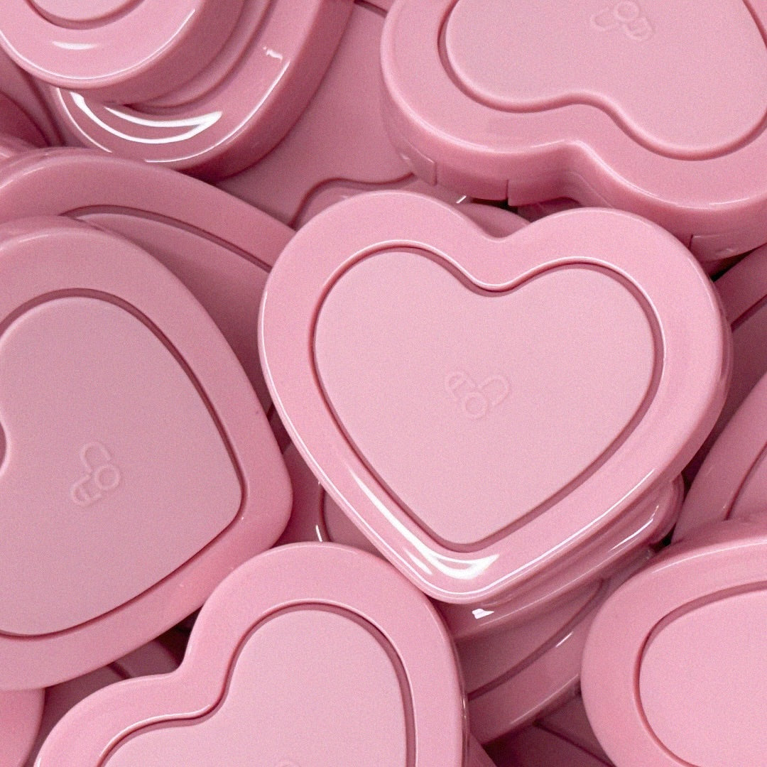 Heart-shaped pink compact cases for AOU Soft Cream Blush stacked together.