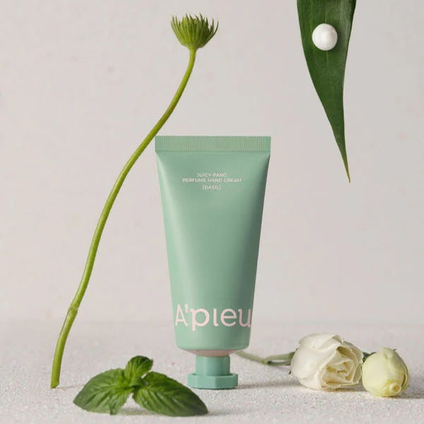 A'PIEU Juicy Pang Perfume Hand Cream 30ml tube displayed with green leaves and white roses.