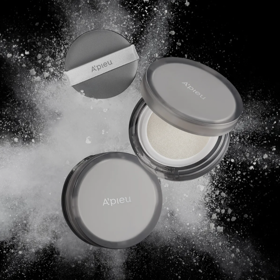 A'PIEU Waterlock Finisher Super Velvet compact powder against a dramatic black background with powder explosion effect.