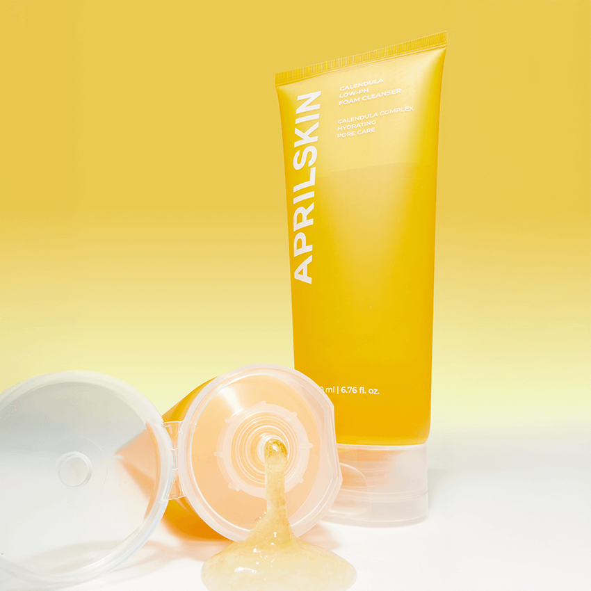 APRILSKIN Calendula Low PH Foam CLeanser in a yellow tube with open cap, showcasing the texture against a matching background