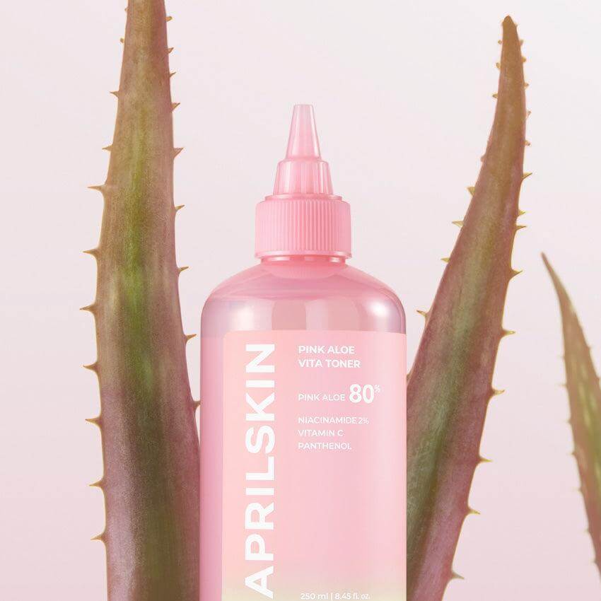 APRILSKIN Pink Aloe Vita Toner bottle with aloe leaves in the background, highlighting the product's natural ingredients and vibrant packaging.