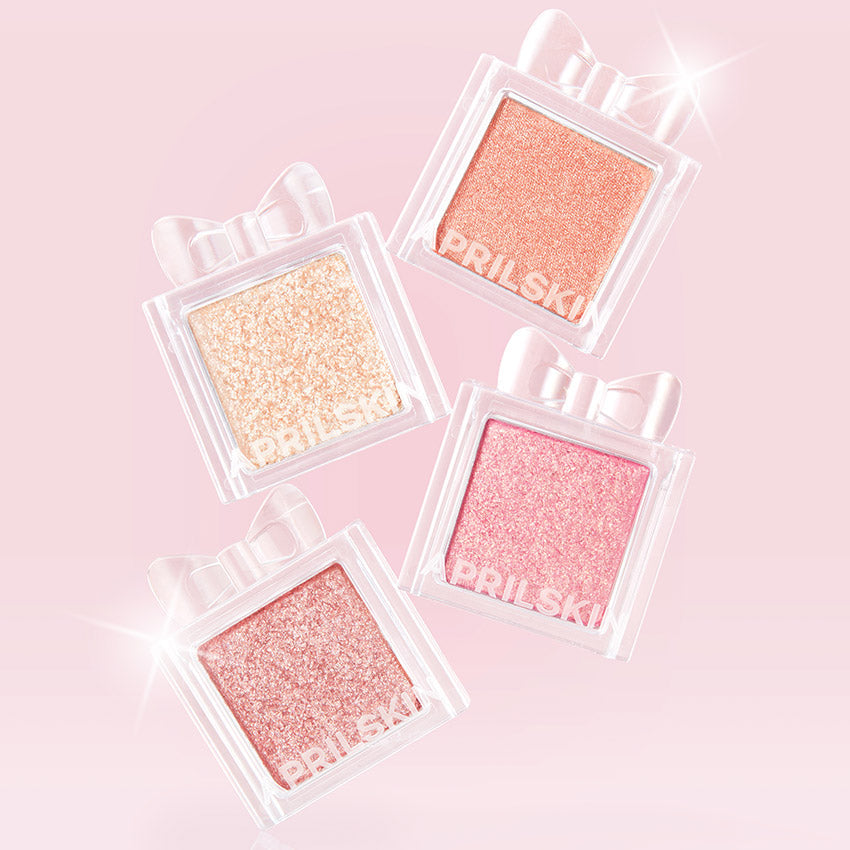 APRILSKIN Slide Pocket Single Shadow in four shimmering shades on a pink background, highlighting glimmer and elegance.