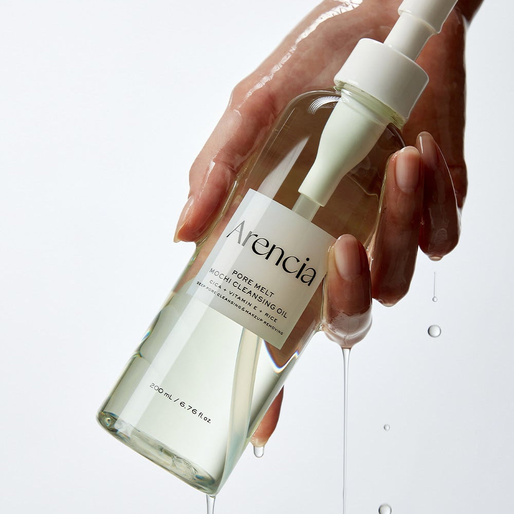 Hand holding ARENCIA Pore Melt Mochi Cleansing Oil 200ml bottle, showcasing product packaging and design.