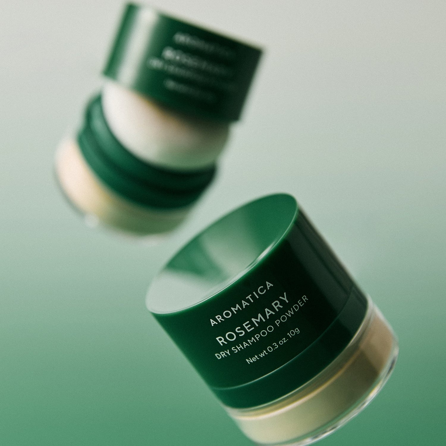 AROMATICA Rosemary Dry Shampoo Powder 10g in green jars against a gradient background
