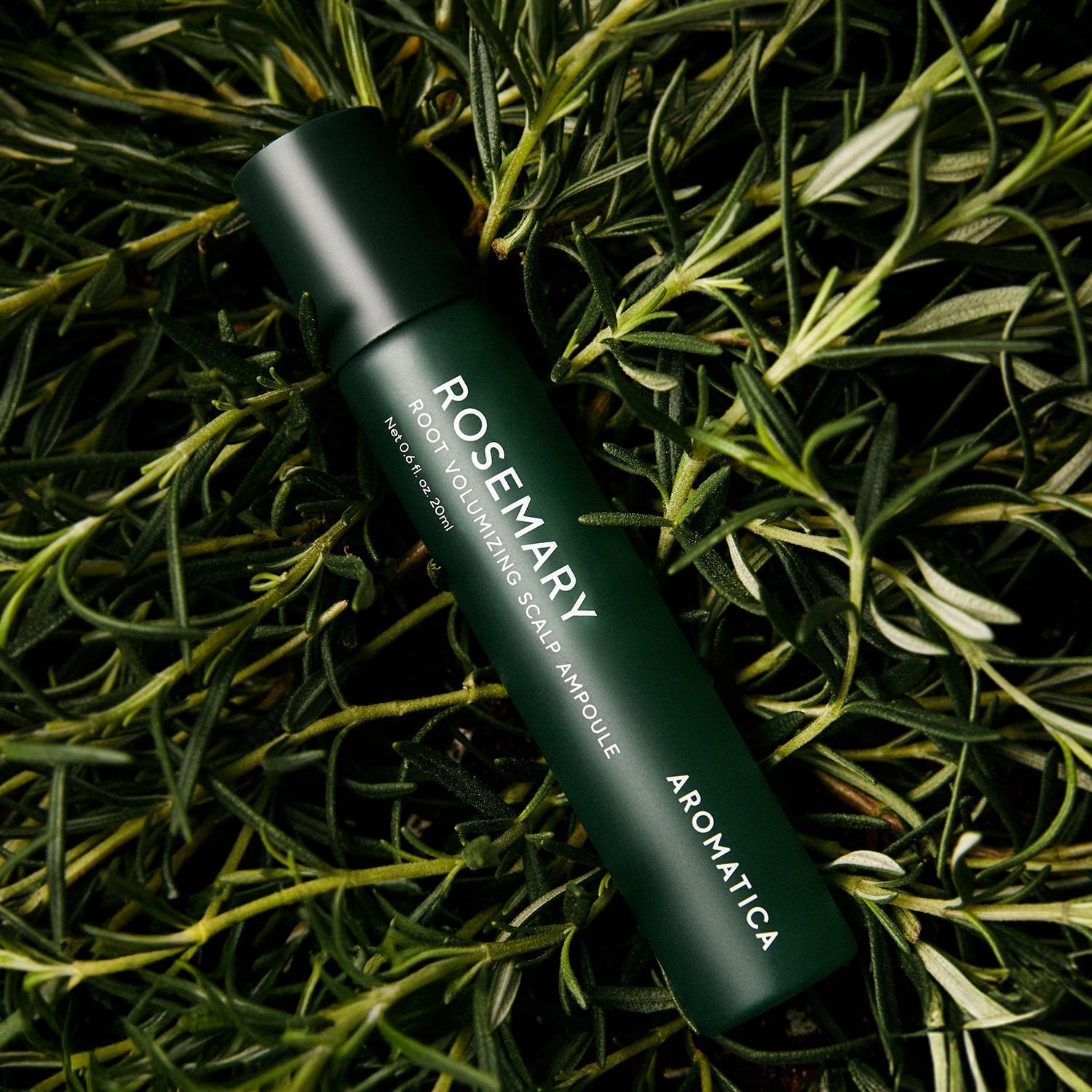 AROMATICA Rosemary Root Volumizing Scalp Ampoule 20ML bottle surrounded by rosemary leaves for hair care.