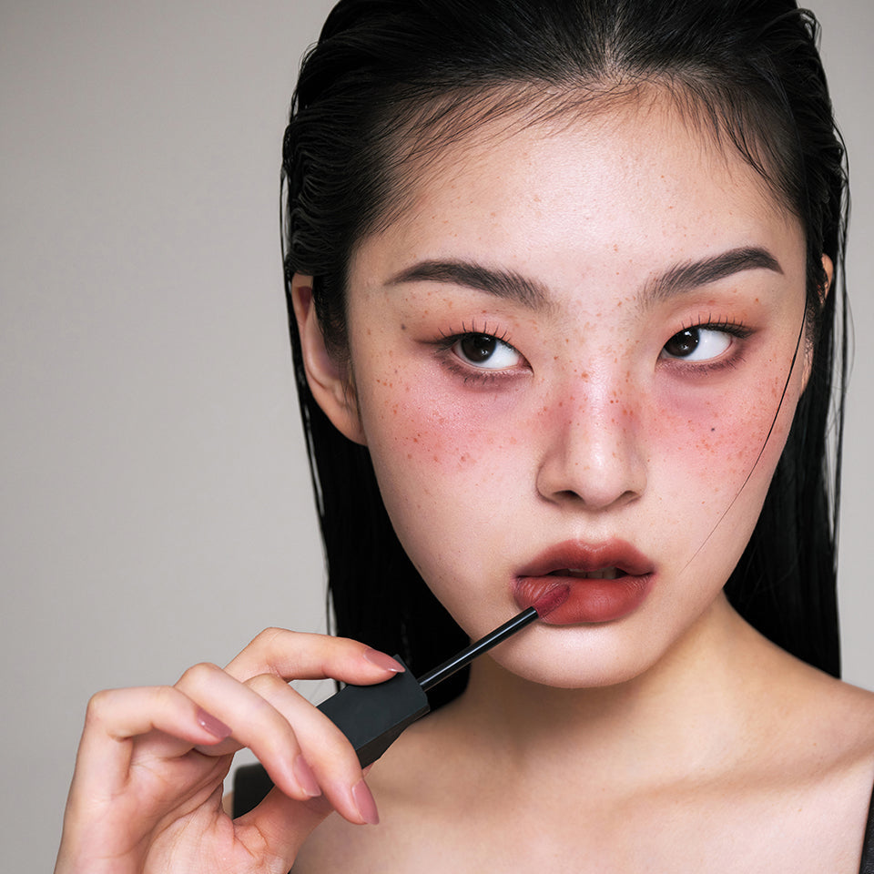 Woman applying ARTESINSA Silky Blur Tints for a flawless lip finish.