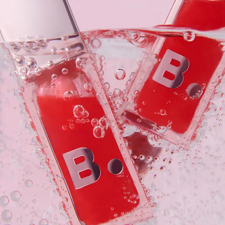 BANILA CO Hydrating Lip Oil bottles in water with bubbles, highlighting the moisturizing formula. Cosmetic beauty product image.