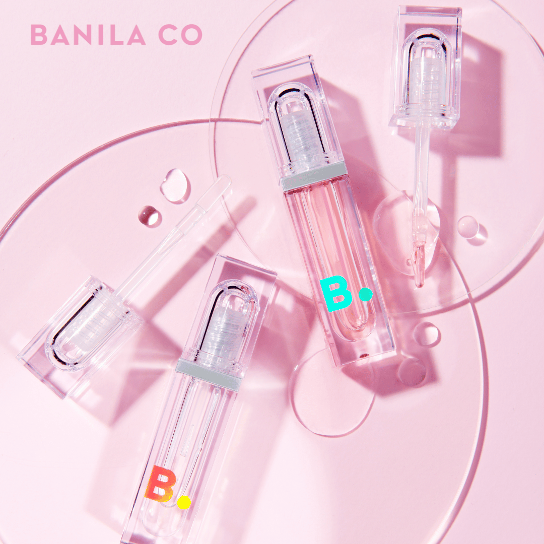 BANILA CO Volume Lip Plumper on a pink background with clear and pink packaging, enhancing lip fullness and shine.