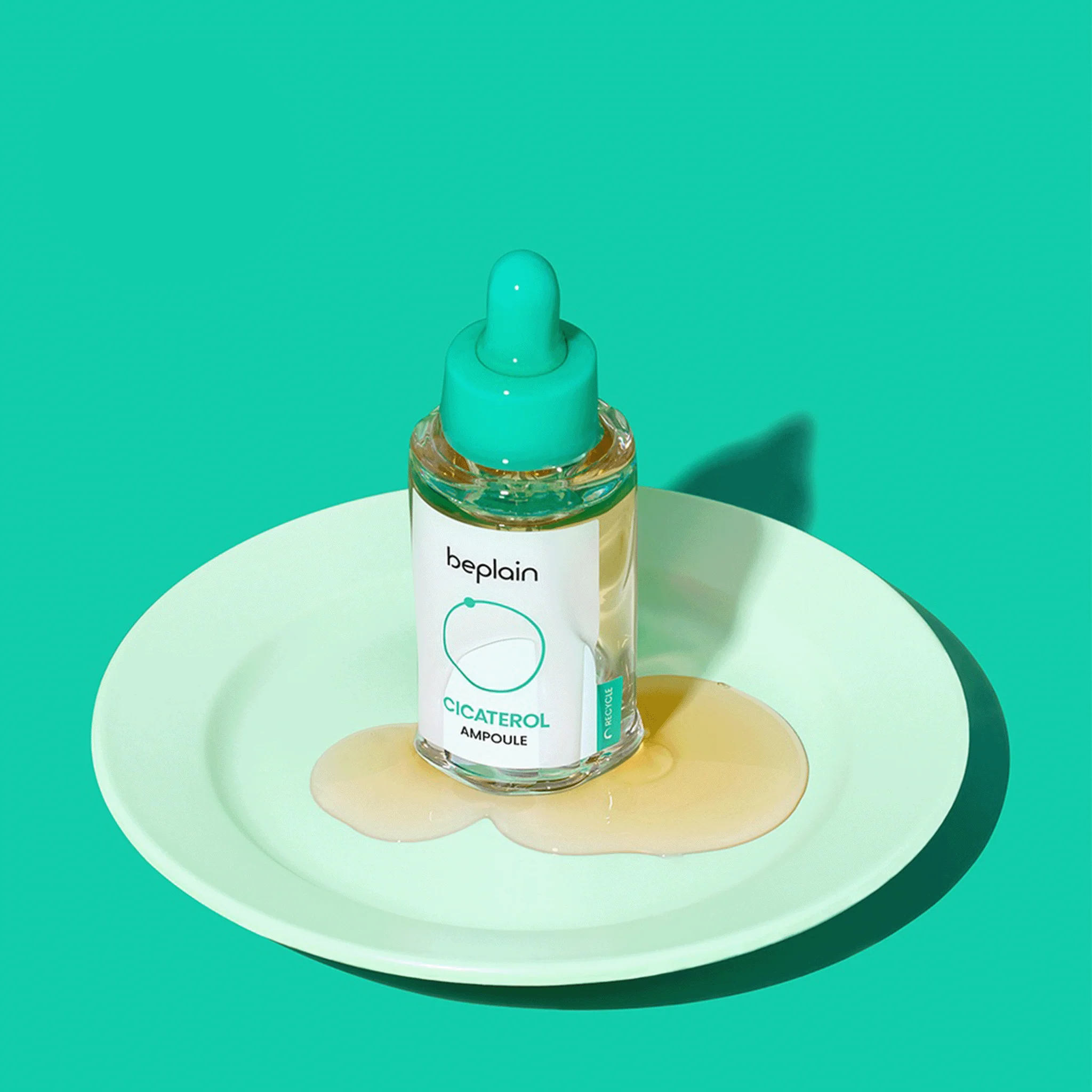 BEPLAIN Cicaterol Ampoule 30ml on a plate with product spillage, showcasing skincare product packaging.