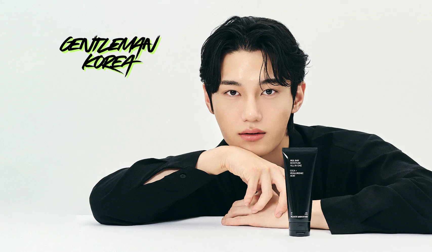 Man posing with skincare product tube "Gentleman Korea" logo in background.