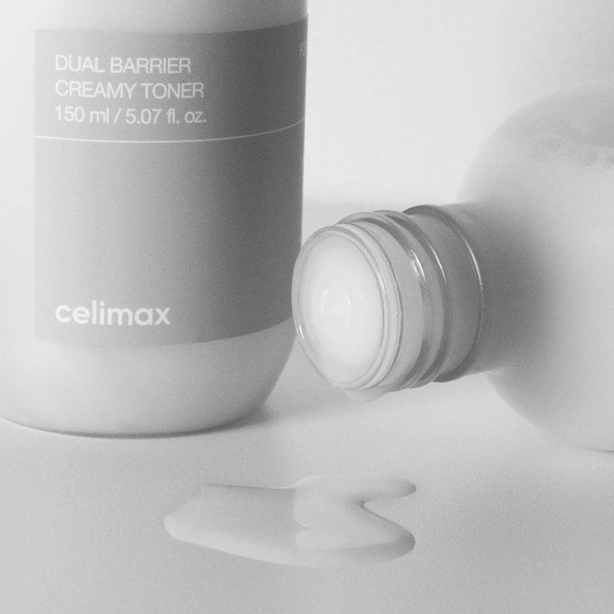 CELIMAX Dual Barrier Creamy Toner 150ml bottle with spilled toner on white surface