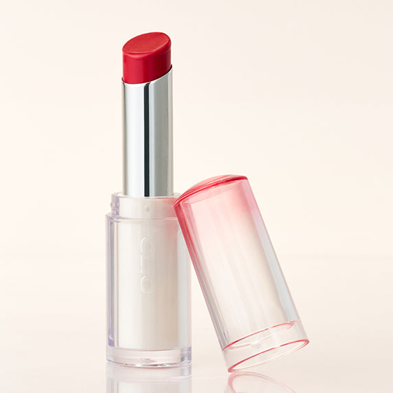 CLIO Crystal Glam Balm in red shade on a white background, featuring a sleek and stylish transparent casing with a pink tint cap.