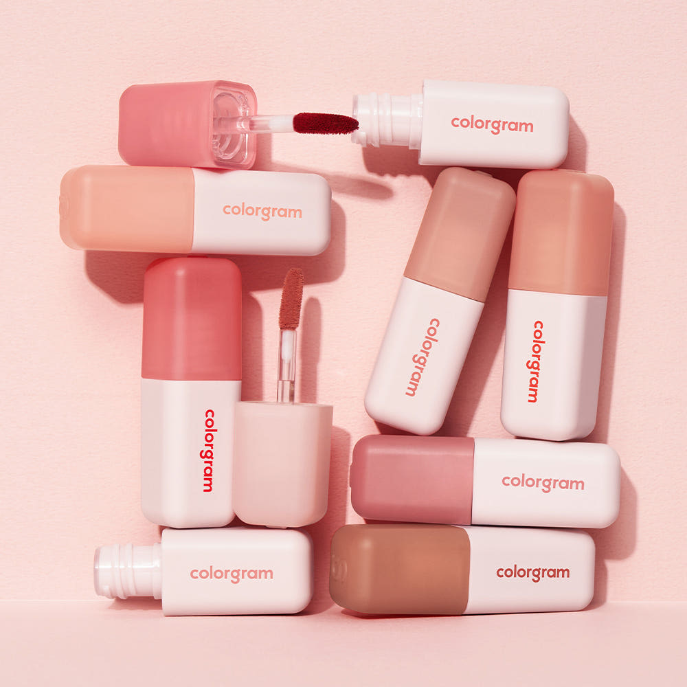 Various COLORGRAM Nude Blur Tint shades on display with stylish packaging.