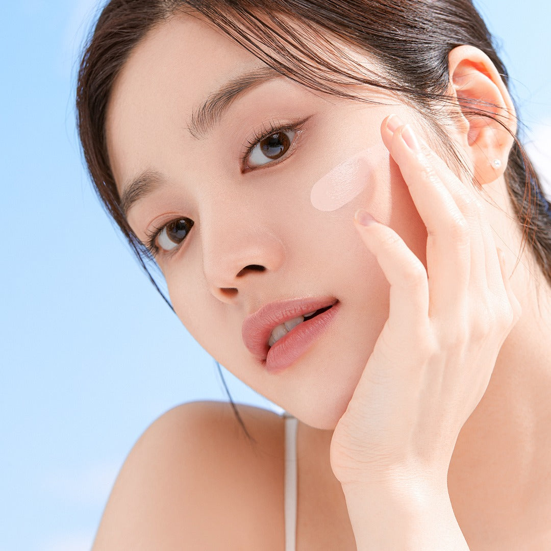 Woman applying CORALHAZE SIlky Glow Tone Up Base for radiant skin