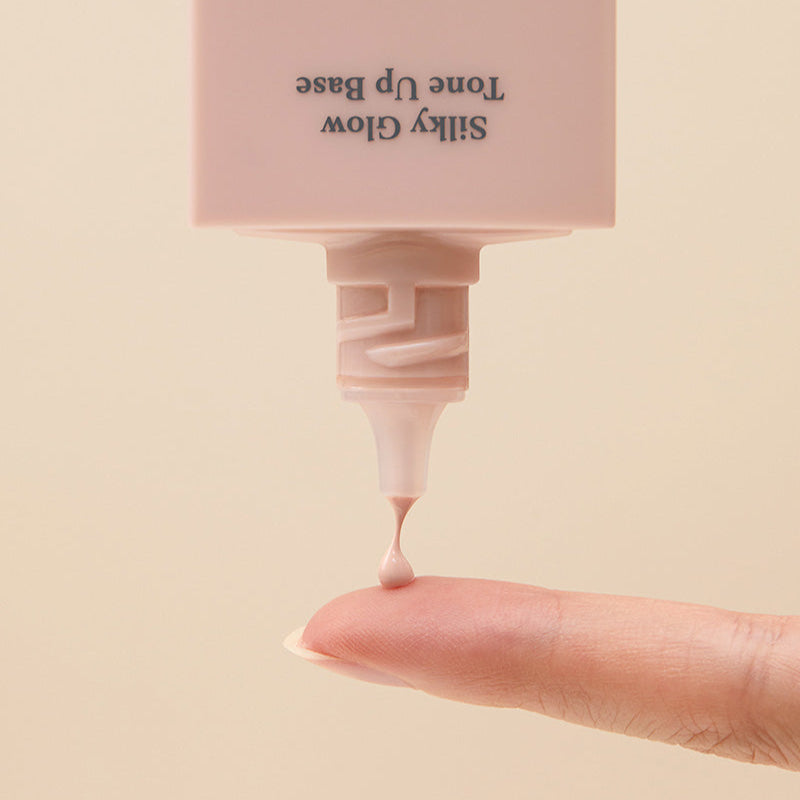 CORALHAZE SIlky Glow Tone Up Base being applied to finger for a radiant finish