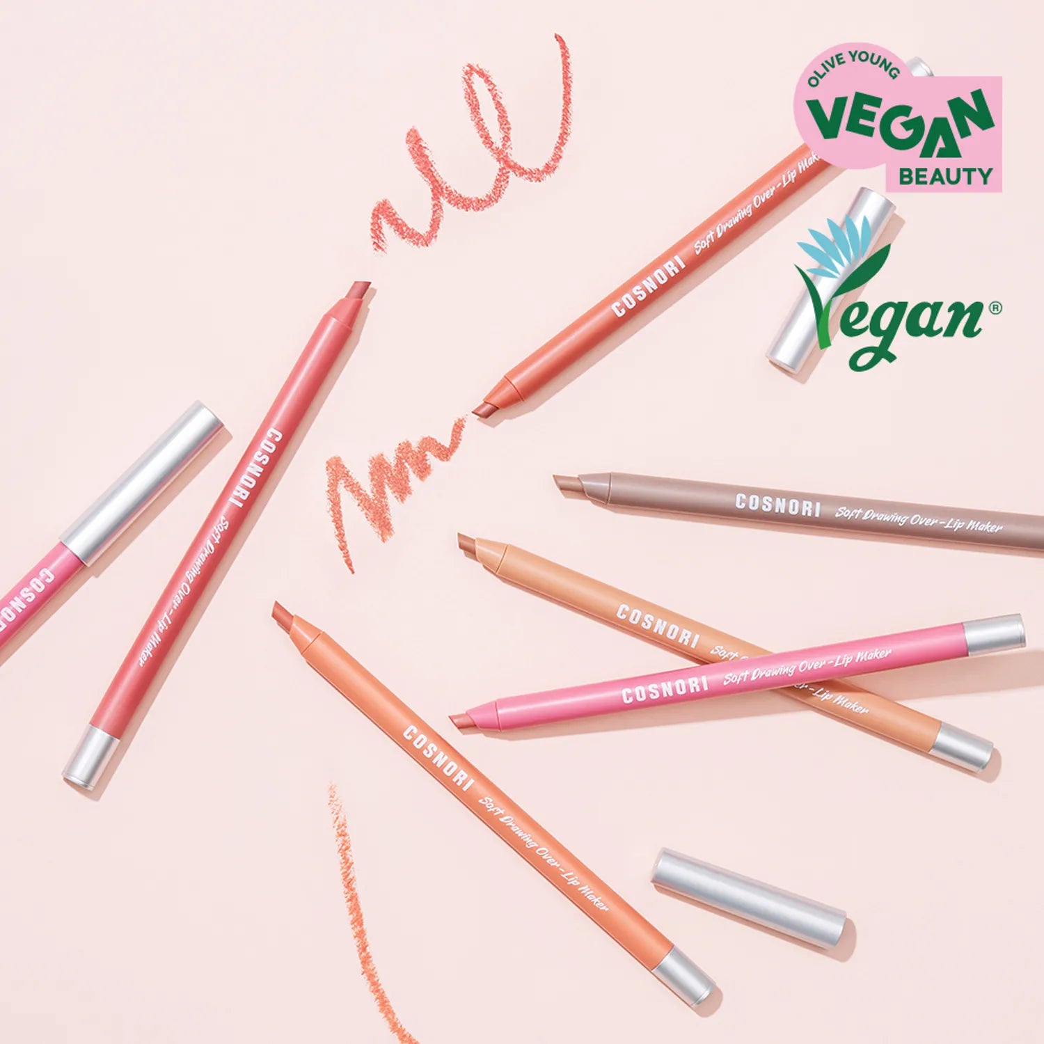 COSNORI Soft Drawing Overlip Maker vegan beauty product lying on a pink surface with various colors and designs.