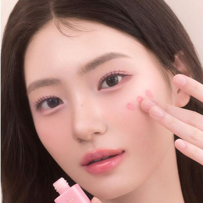 Woman applying DASIQUE Silky Veil Blush on cheeks for a natural rosy glow.