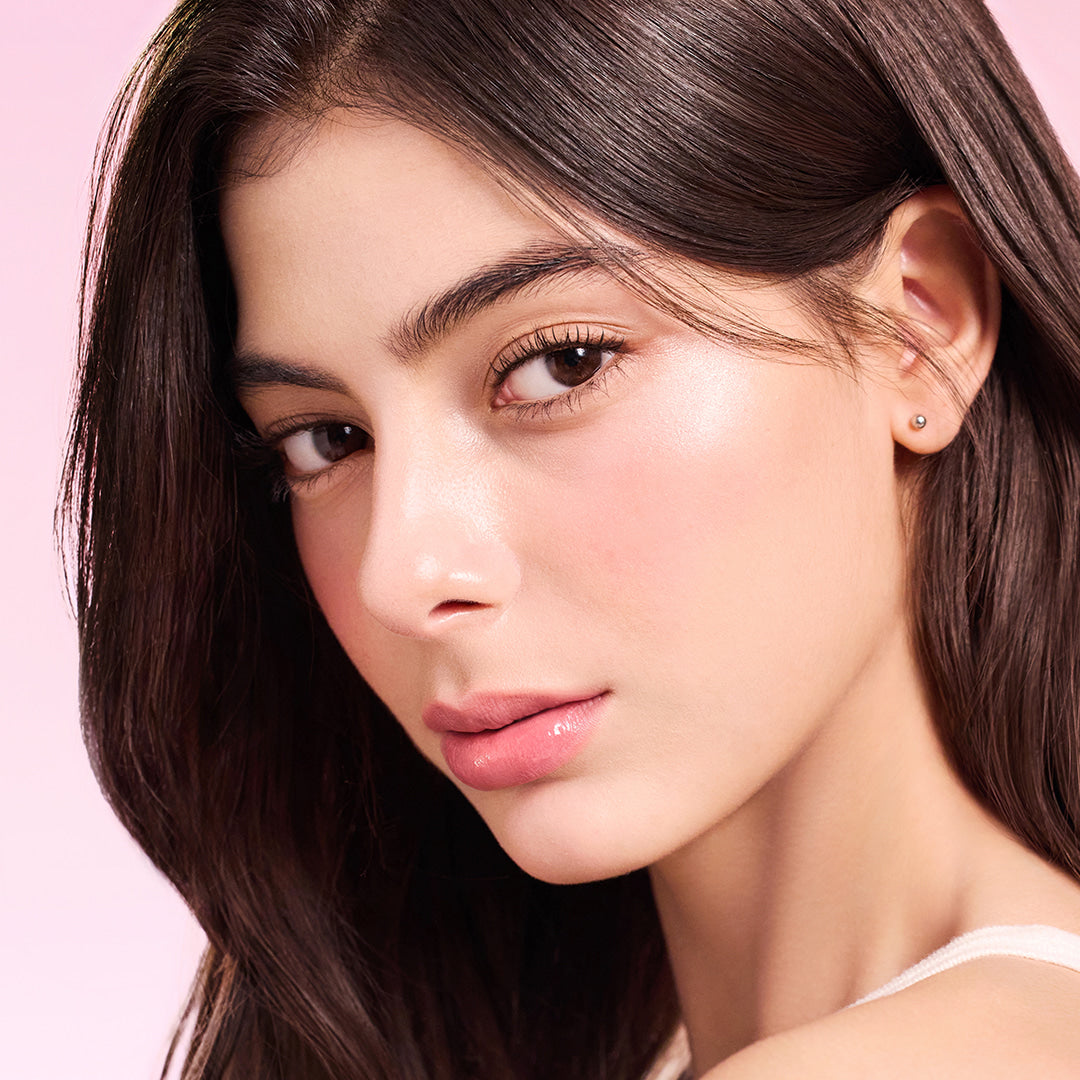 Model wearing DEAR DAHLIA Lip Paradise Sensual Lip Glow with a natural makeup look