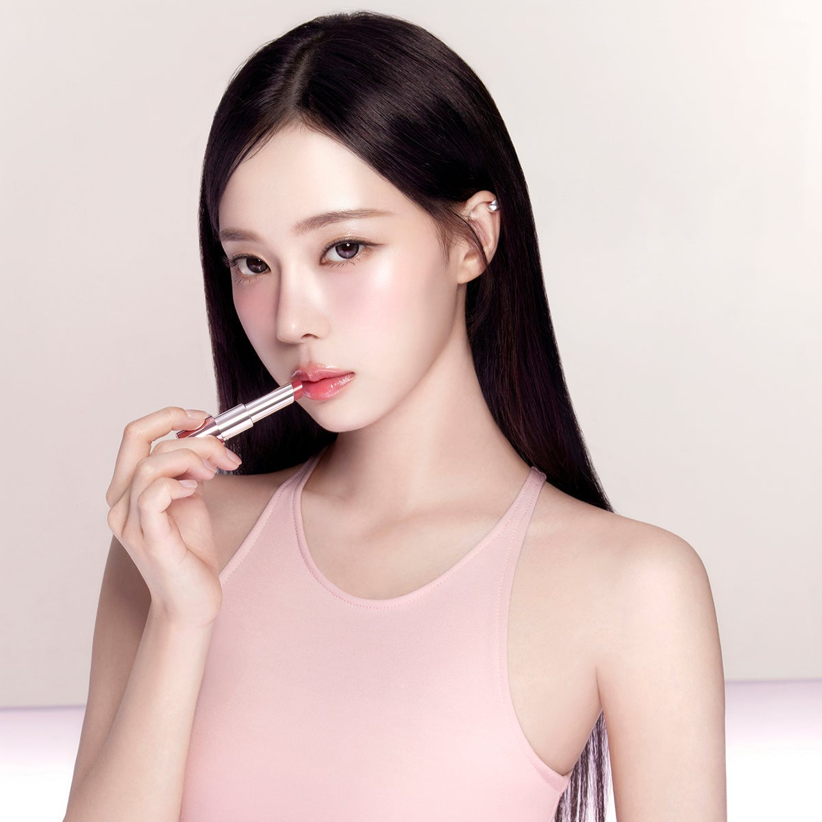 Woman applying ESPOIR Bare Glow Lip Balm for a subtle shine and hydration.