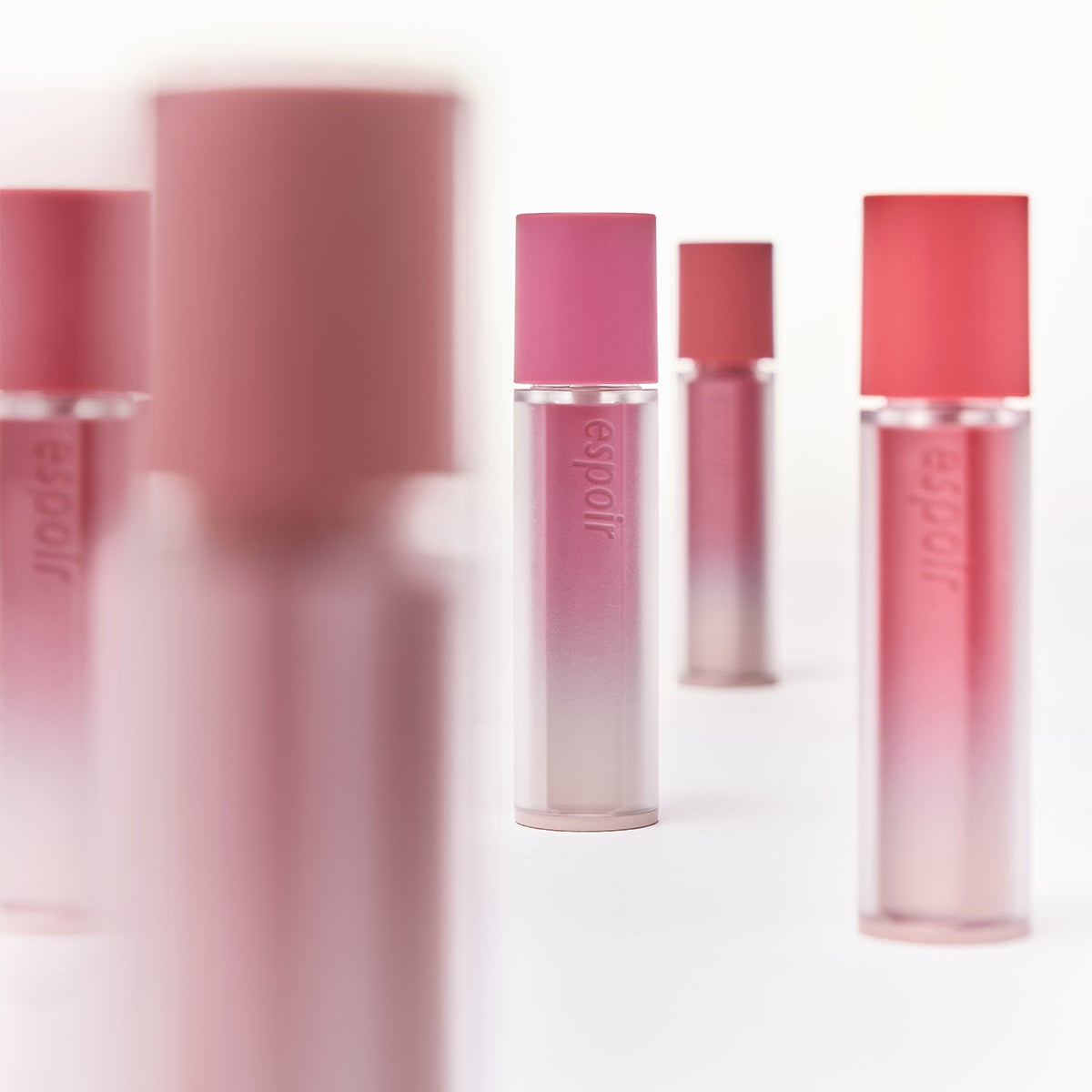 ESPOIR Couture Lip Tint Fitting Blur tubes displayed in soft focus with various shades on a white background