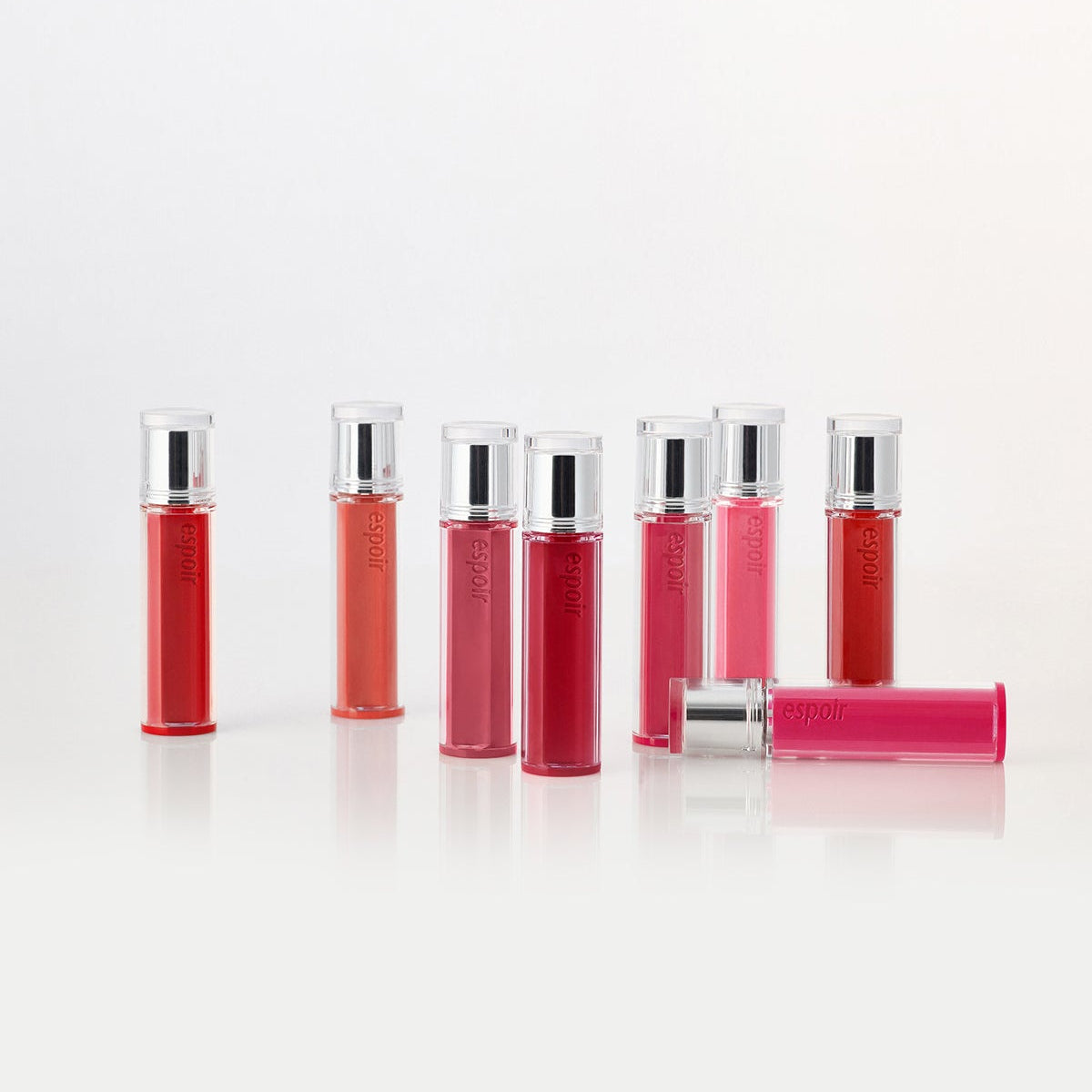 Collection of ESPOIR Couture Lip Tint Glaze in various shades displayed in tubes.