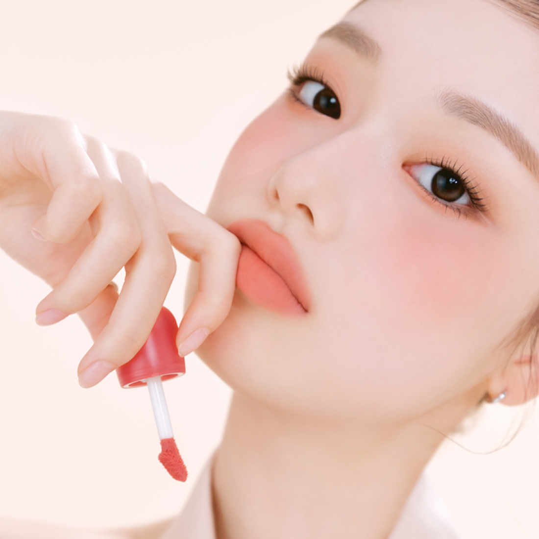 Model applying ETUDE Cozy Fixing Tint 4g to lips, showcasing rich color and smooth finish.