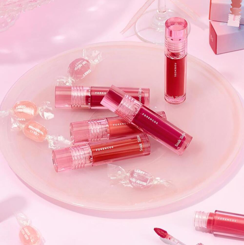 FORENCOS Renewal Tattoo Tint lip colors arranged on a pink plate with candies, showcasing vibrant shades for long-lasting wear.