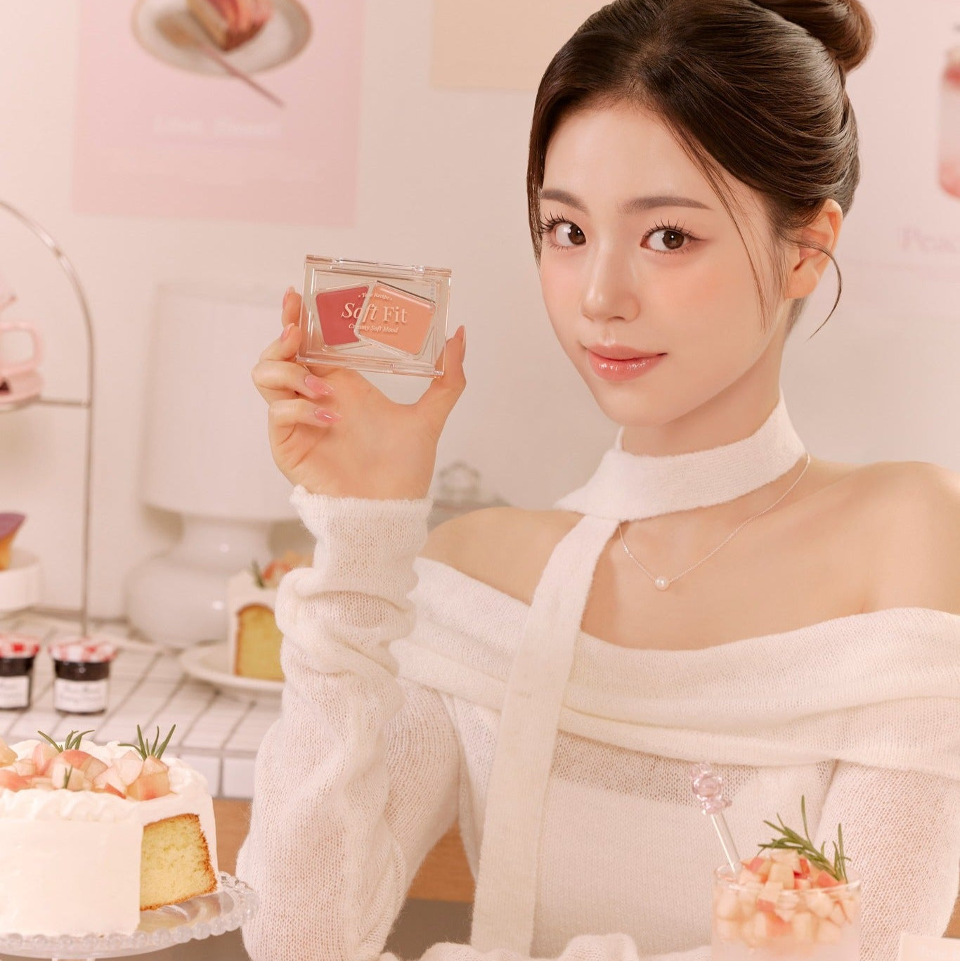 Person holding FORENCOS Soft Fitting Cream Blusher near cakes in cozy setting.