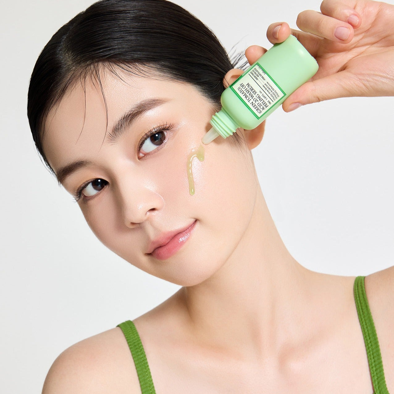 Woman applying FULLY Green Tomato Acid 20 Wash-Off Peeling Serum 50ml on her cheek for skincare routine.