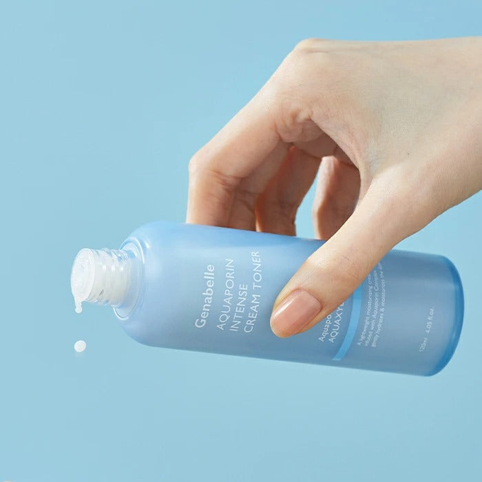 Hand holding GENABELLE Aquaporin Intense Cream Toner 120ml bottle with blue background