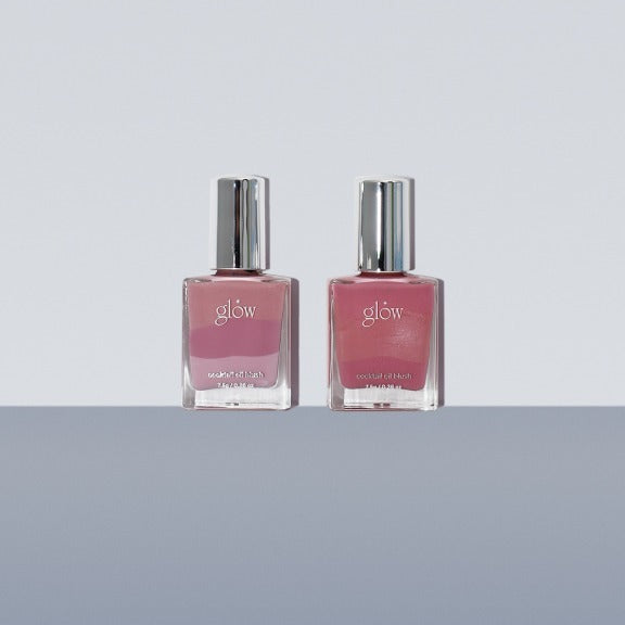 Two bottles of GLOW Cocktail Oil Blusher 7.5g on a gray surface