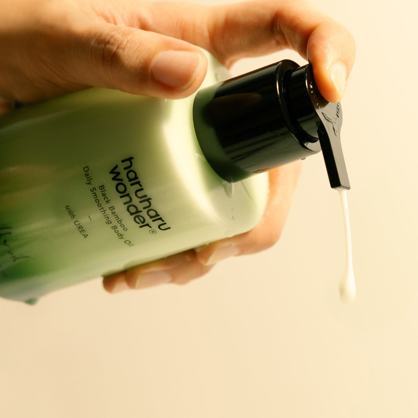 Dispensing HARUHARU Black Bamboo Daily Smoothing Body Oil 200ml from a bottle.
