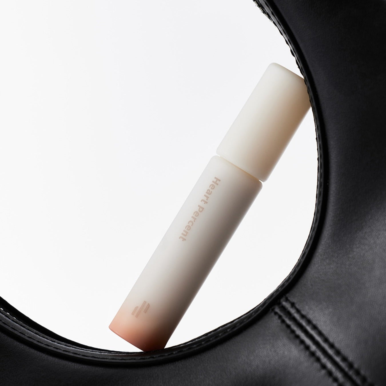 HEART PERCENT Dot On Mood All Cover Lip Base displayed creatively with a black leather frame.