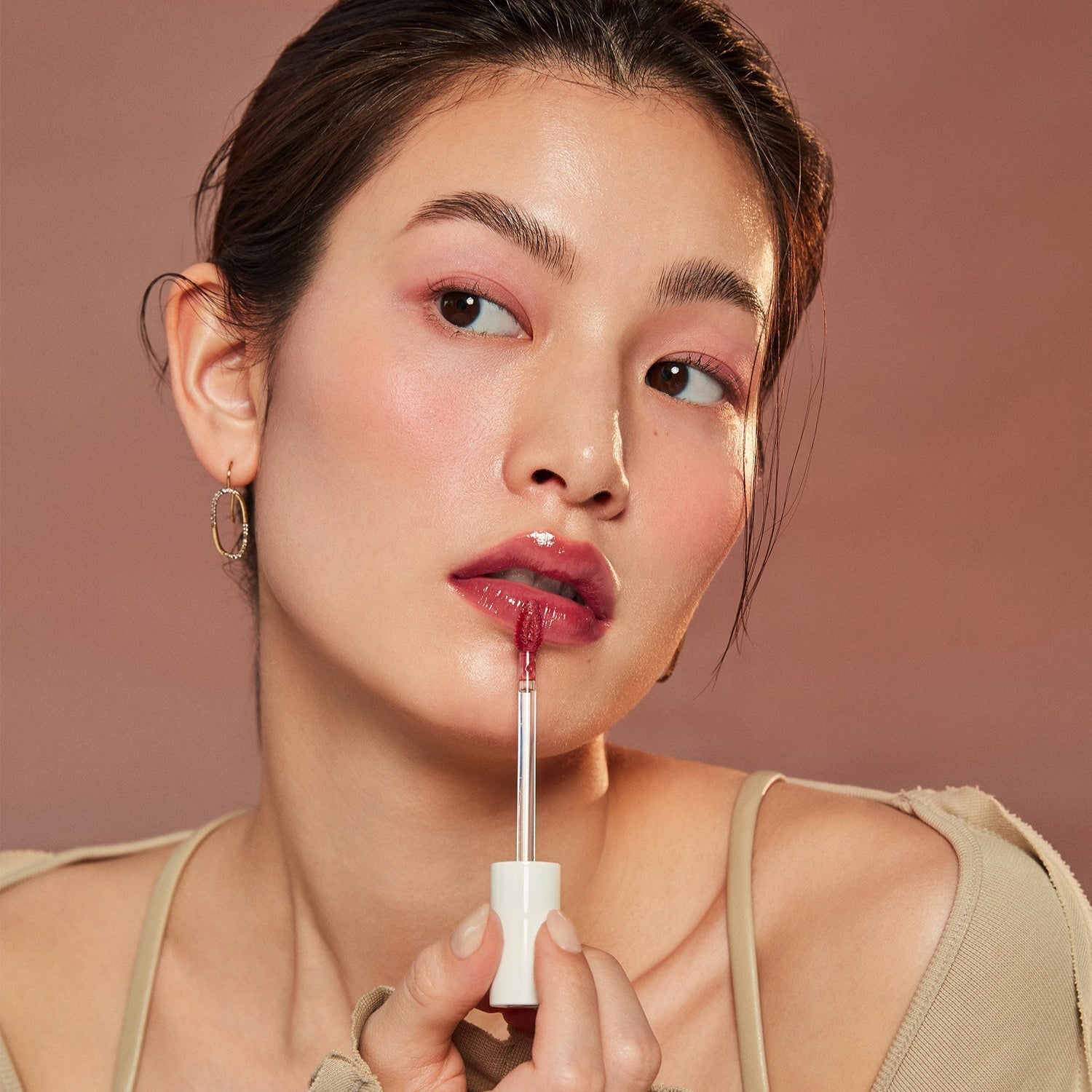 Woman applying HINCE Mood Enhancer Water Liquid Glow to lips