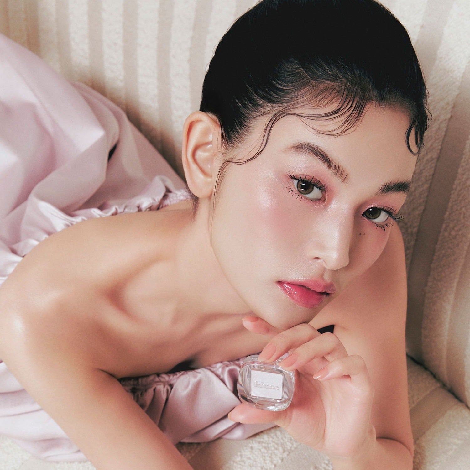 Model holding HINCE Single Eyeshadow, showcasing makeup application