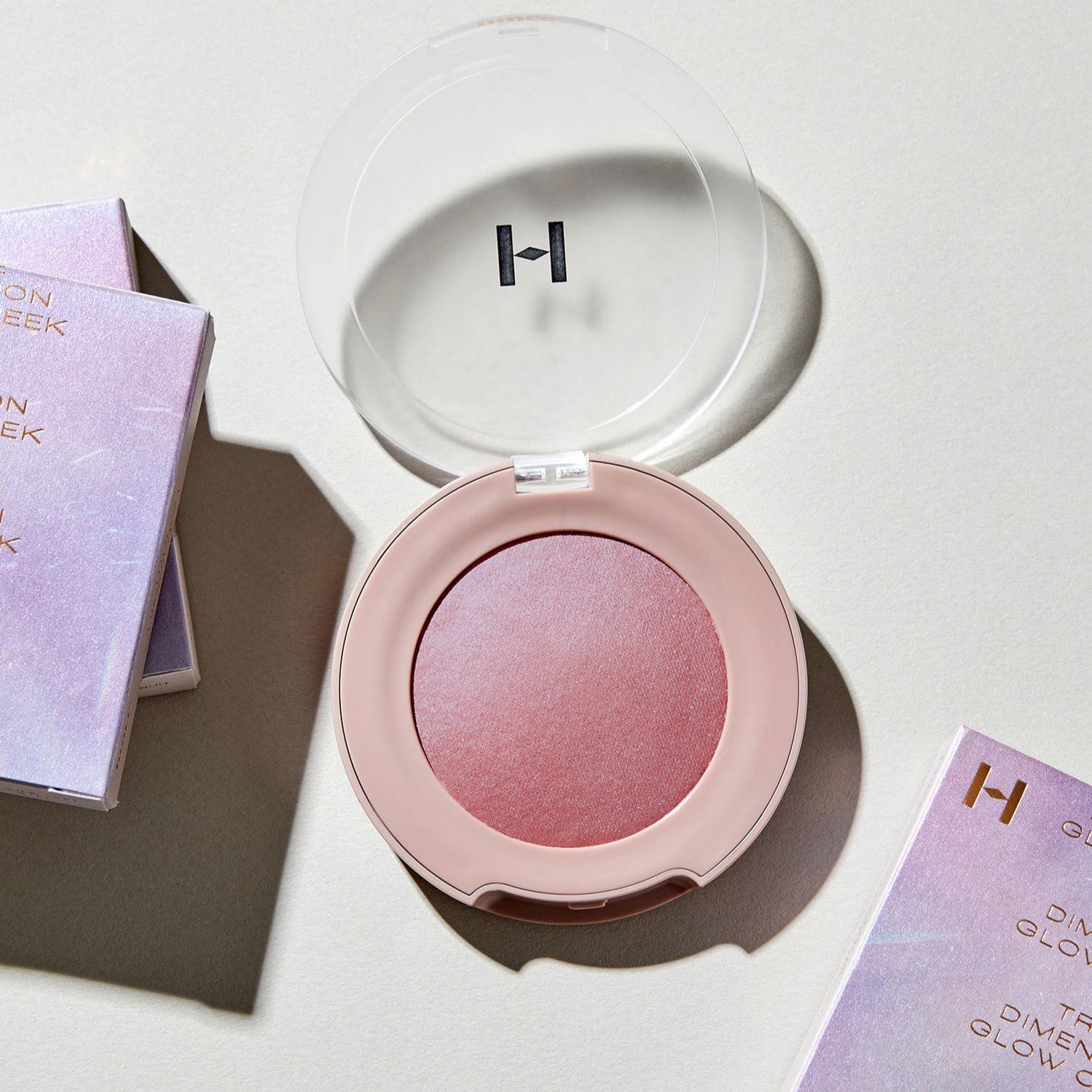 HINCE True Dimension Glow Cheek in open compact with packaging, showcasing radiant blush color on a light background.