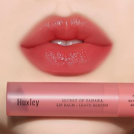 Close-up of lips wearing HUXLEY Lip Balm Leave Behide, showcasing the product's moisturizing effect and vibrant color.